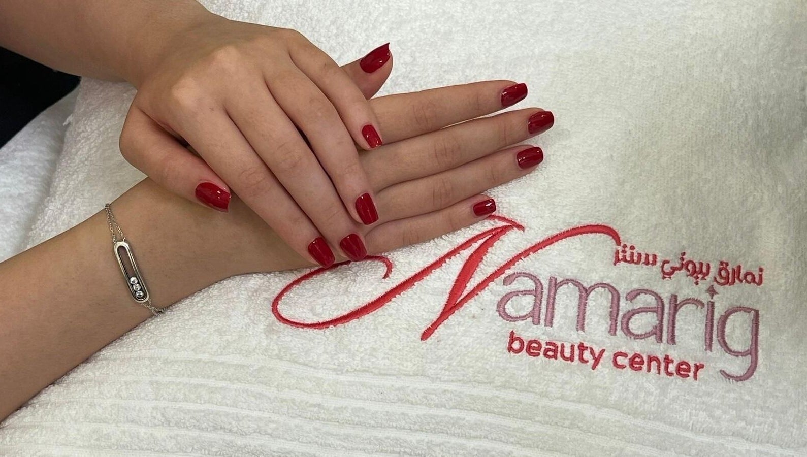 Elegant red manicured nails at Namarig beauty center, Doha, Doha Municipality, QA, on logo towel.