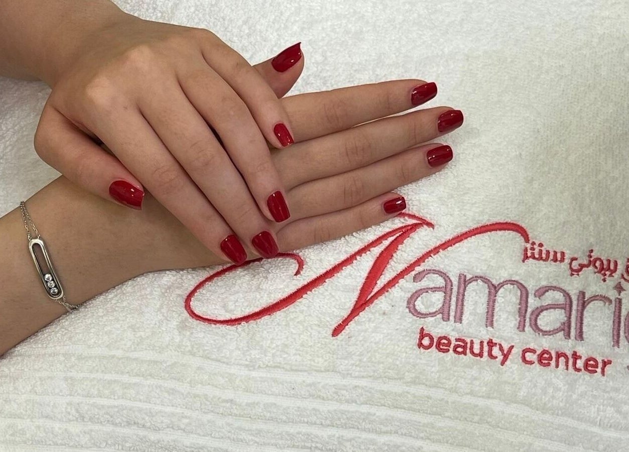 Elegant red manicured nails at Namarig beauty center, Doha, Doha Municipality, QA, on logo towel.