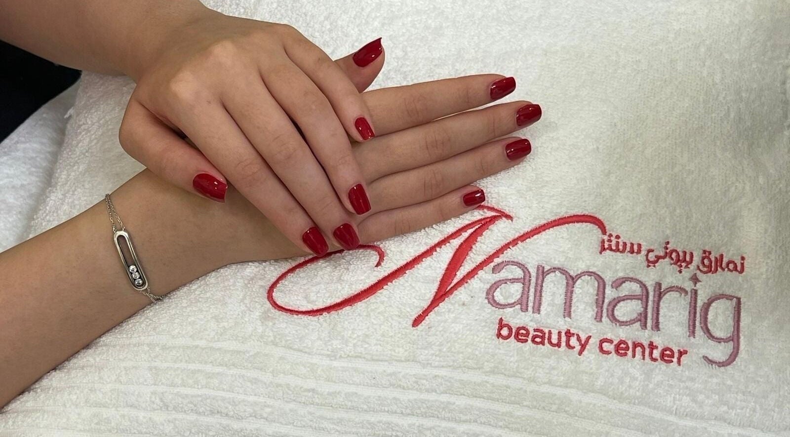 Elegant red manicured nails at Namarig beauty center, Doha, Doha Municipality, QA, on logo towel.