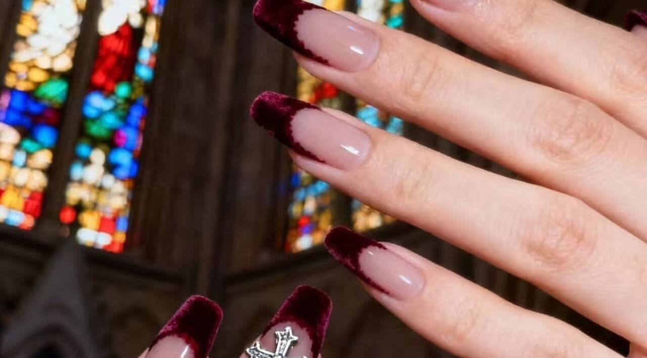 Elegant burgundy velvet nails at 14 haymarket terrace, Edinburgh, Scotland, GB with a cathedral backdrop.