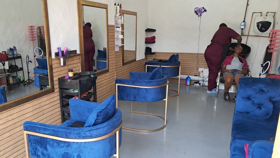 Modern salon interior with blue chairs at Rooted Hair Co, Pretoria, Gauteng, ZA.