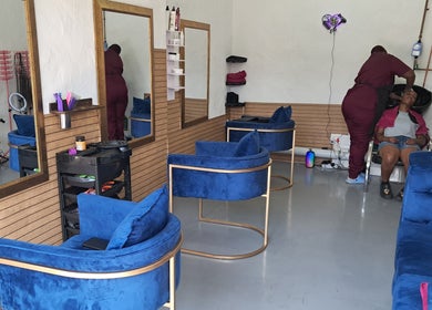 Modern salon interior with blue chairs at Rooted Hair Co, Pretoria, Gauteng, ZA.