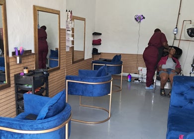 Interior of Rooted Hair Co in Pretoria, Gauteng, ZA, showcasing stylish blue seating and a hair wash area.