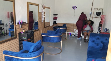 Interior of Rooted Hair Co in Pretoria, Gauteng, ZA, showcasing stylish blue seating and a hair wash area.