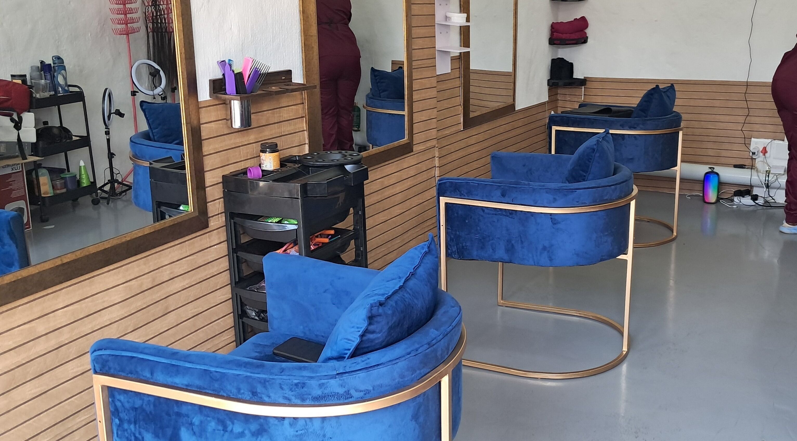 Modern salon interior with blue chairs at Rooted Hair Co, Pretoria, Gauteng, ZA.