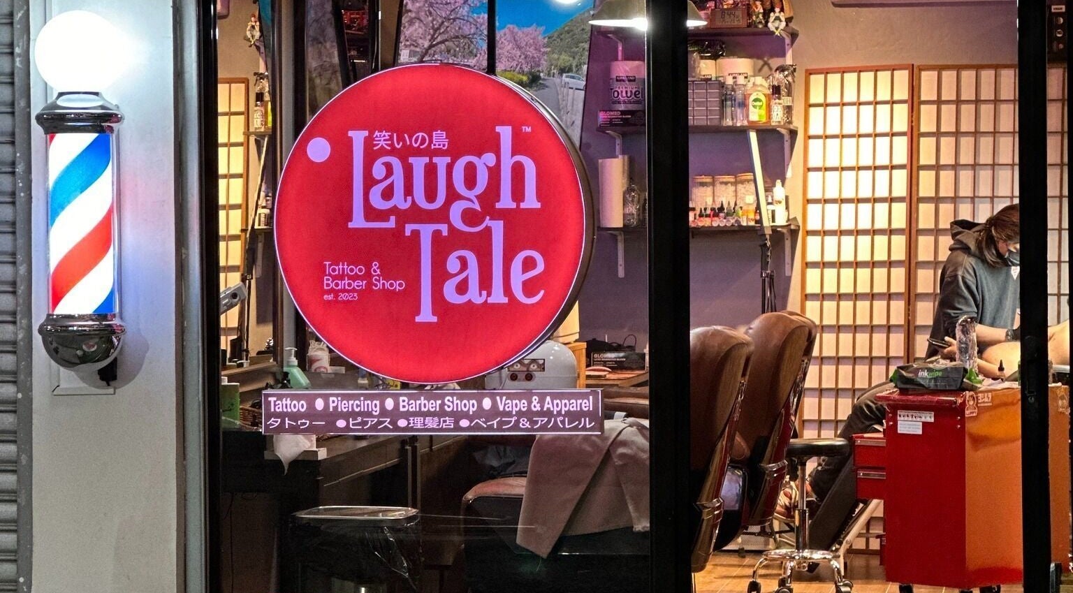 Laugh Tale Tattoo & Barber Shop front view, showcasing barber pole and signage in Kawit, Calabarzon, PH.