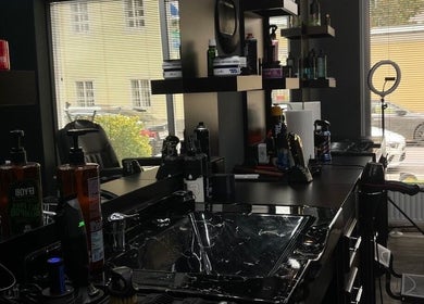 Moderne Friseurstation bei BG Hairstyle in Wels, Oberösterreich, AT, mit stilvollem Spiegel und Produkten.