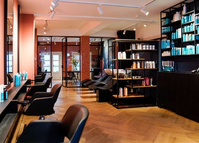 Interior of Hair salon Westerstraat in Amsterdam, Noord-Holland, NL featuring modern chairs and shelves.