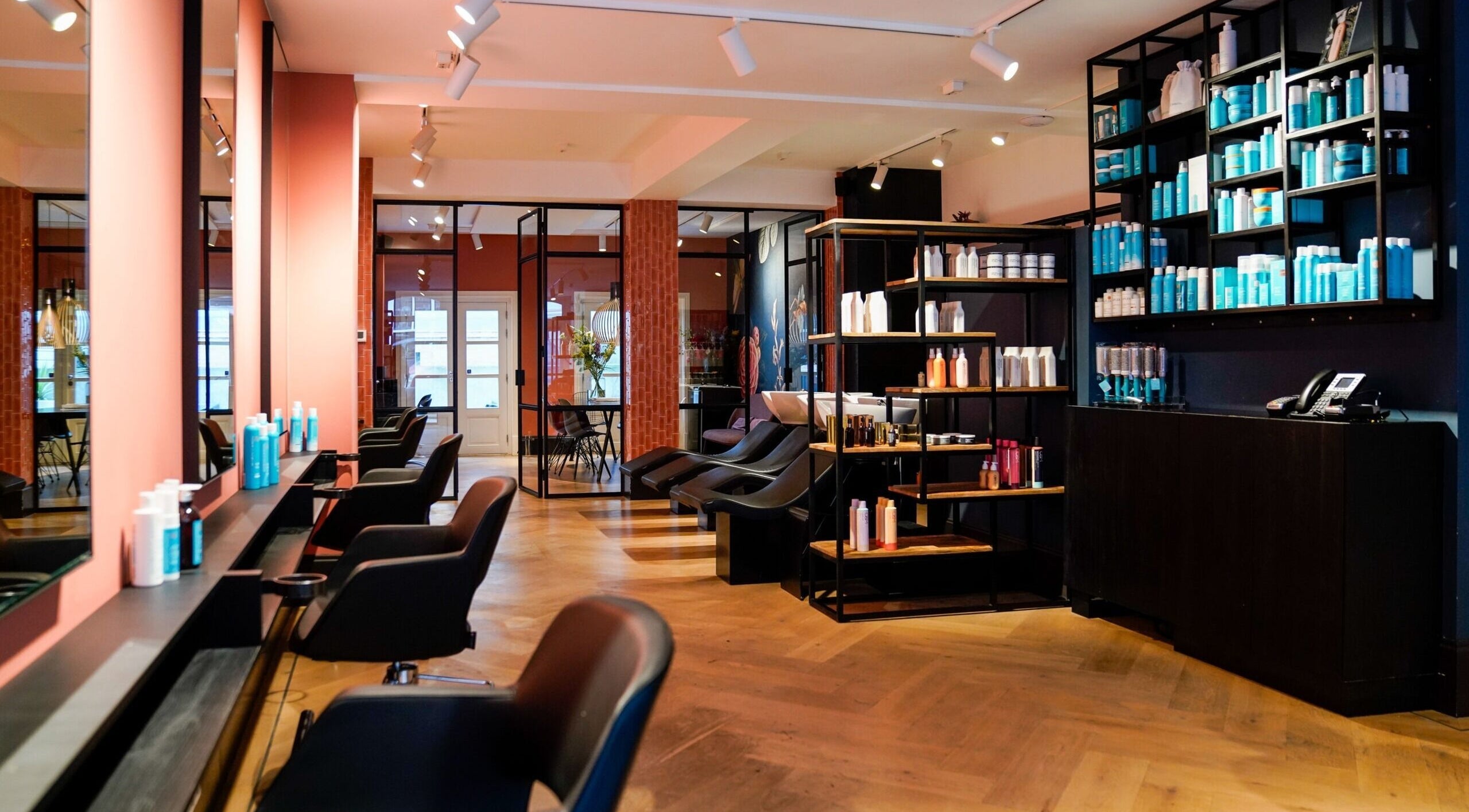 Elegant interior of Day&Night Hairdressers Westerstraat in Amsterdam, Noord-Holland, NL, featuring sleek salon chairs and product shelves.
