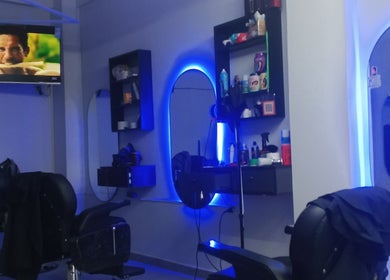 Interior moderno de FUSSION BARBER en Santa Cruz De La Sierra, BO con sillas y espejo iluminado.