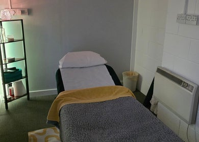 Relaxing treatment room at The Thera Pt in Blackburn, Scotland, GB featuring a massage table and ambient lighting.