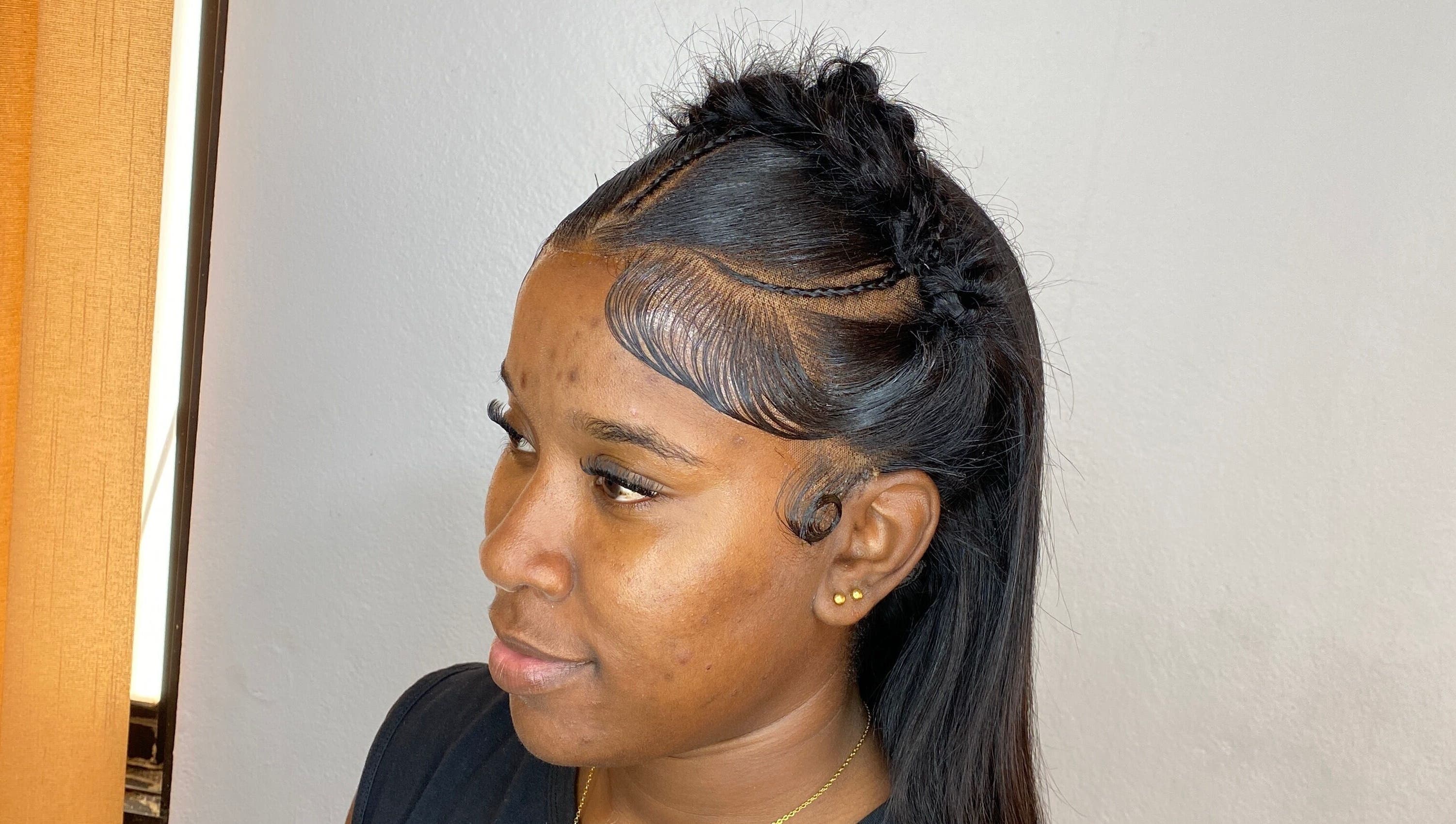 Elegant braided hairstyle at HAIRBYDAE98 in Kingston, JM. Side view showcasing sleek edges and intricate design.