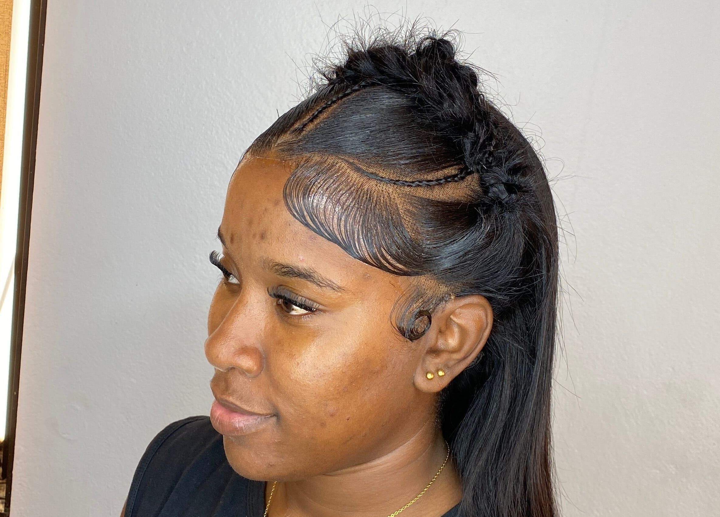 Elegant braided hairstyle at HAIRBYDAE98 in Kingston, JM. Side view showcasing sleek edges and intricate design.