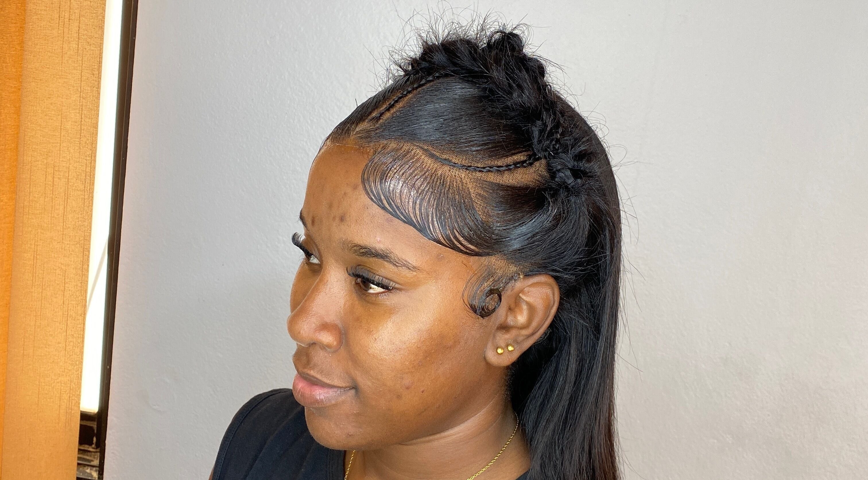 Elegant braided hairstyle at HAIRBYDAE98 in Kingston, JM. Side view showcasing sleek edges and intricate design.