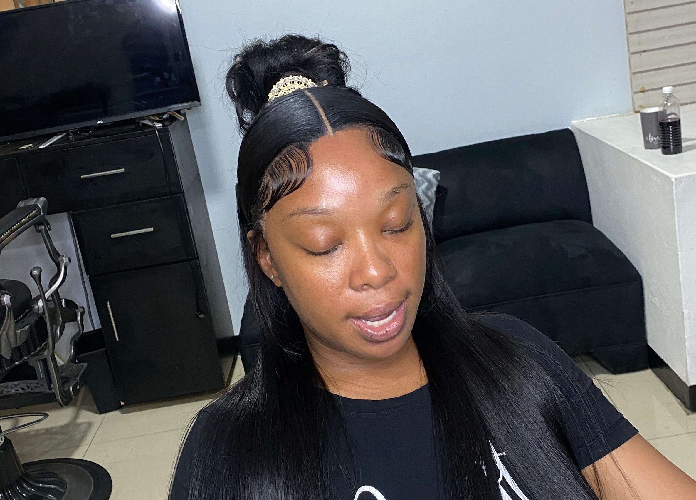Woman with styled hair at HAIRBYDAE98 salon in Kingston, JM, showcasing professional beauty services.