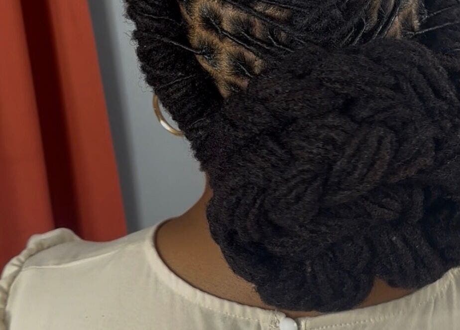 Intricate loc bun hairstyle at Loc’d n Kee, The Quarter, AI.