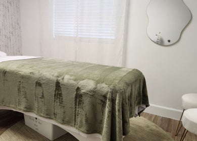 Relaxing massage room at Marinez Maia Aesthetic & Massage in Orlando, Florida, US with soft green decor.