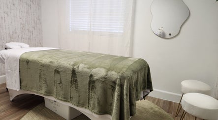 Relaxing massage room at Marinez Maia Aesthetic & Massage in Orlando, Florida, US with soft green decor.