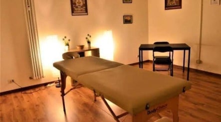 Sala massaggi accogliente di Armonie Spa a Torino, Piemonte, IT, con tavolo massaggi e luci soffuse.