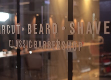 Interior view through glass at Frank Barber Shop, Panamá, Provincia De Panamá, PA, with haircut services listed.