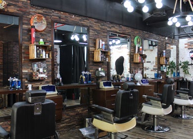 Interior of Tornado Gents Salon - JLT, Dubai, Dubai, AE showcasing vintage barber chairs and rustic décor.