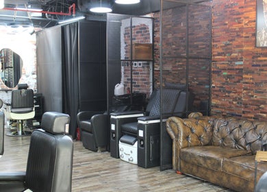Stylish interior of Tornado Gents Salon - JLT in Dubai, Dubai, AE with modern barber chairs and leather sofa.