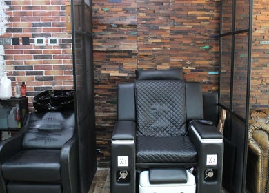 Comfortable salon chair at Tornado Gents Salon - JLT, Dubai, Dubai, AE, with a stylish brick backdrop.