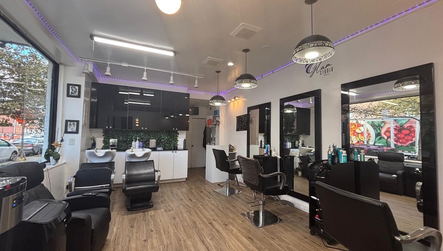 Interior moderno de Glam Studio NYC, New York, New York, US, con sillas de peluquería elegantes.