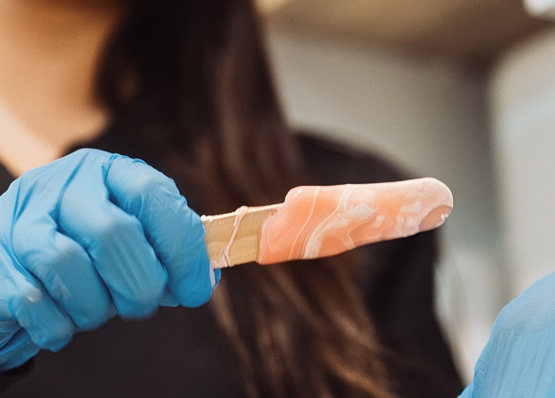 Professional waxing at Hands-On Laser Cosmetic Clinic, Melbourne, Victoria, AU with blue-gloved hands.