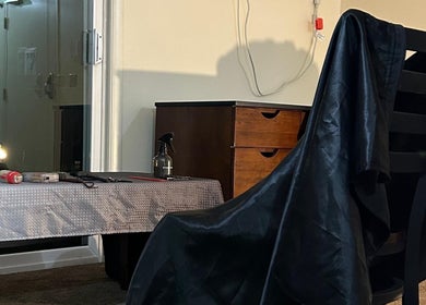 Haircut station at FT Cuts in Sylvania, Ohio, US, featuring tools and a sleek black cape.