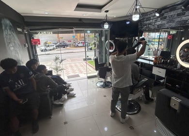 Interior de Markus en Pueblo Libre, Provincia De Lima, PE, mostrando estilista trabajando y clientes esperando.