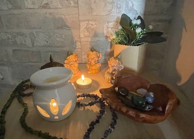 Decoração relaxante com vela e figuras na Tânia_massoterapeuta, Loures, PT, criando um ambiente de paz.