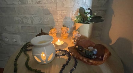 Decoração relaxante com vela e figuras na Tânia_massoterapeuta, Loures, PT, criando um ambiente de paz.