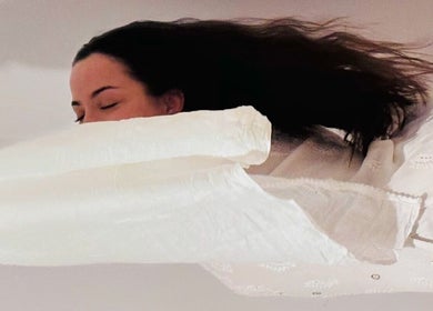 Mulher relaxando em Tânia_massoterapeuta, Loures, PT, envolta em lençóis brancos.