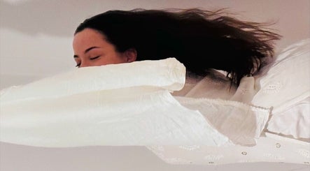 Mulher relaxando em Tânia_massoterapeuta, Loures, PT, envolta em lençóis brancos.