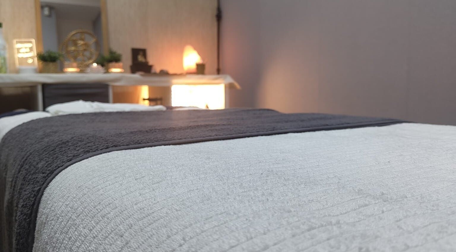 Cama de massagem no espaço Tânia Portela em Sacavém, Lisboa, PT, com decoração suave e iluminação quente.