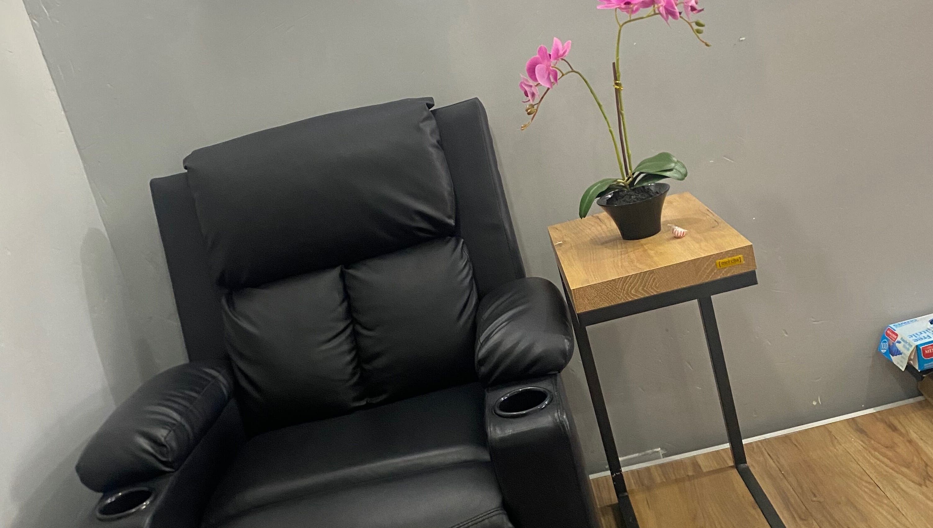 Plush black chair with orchid plant at Snique Allure, Montego Bay, St. James Parish, JM.
