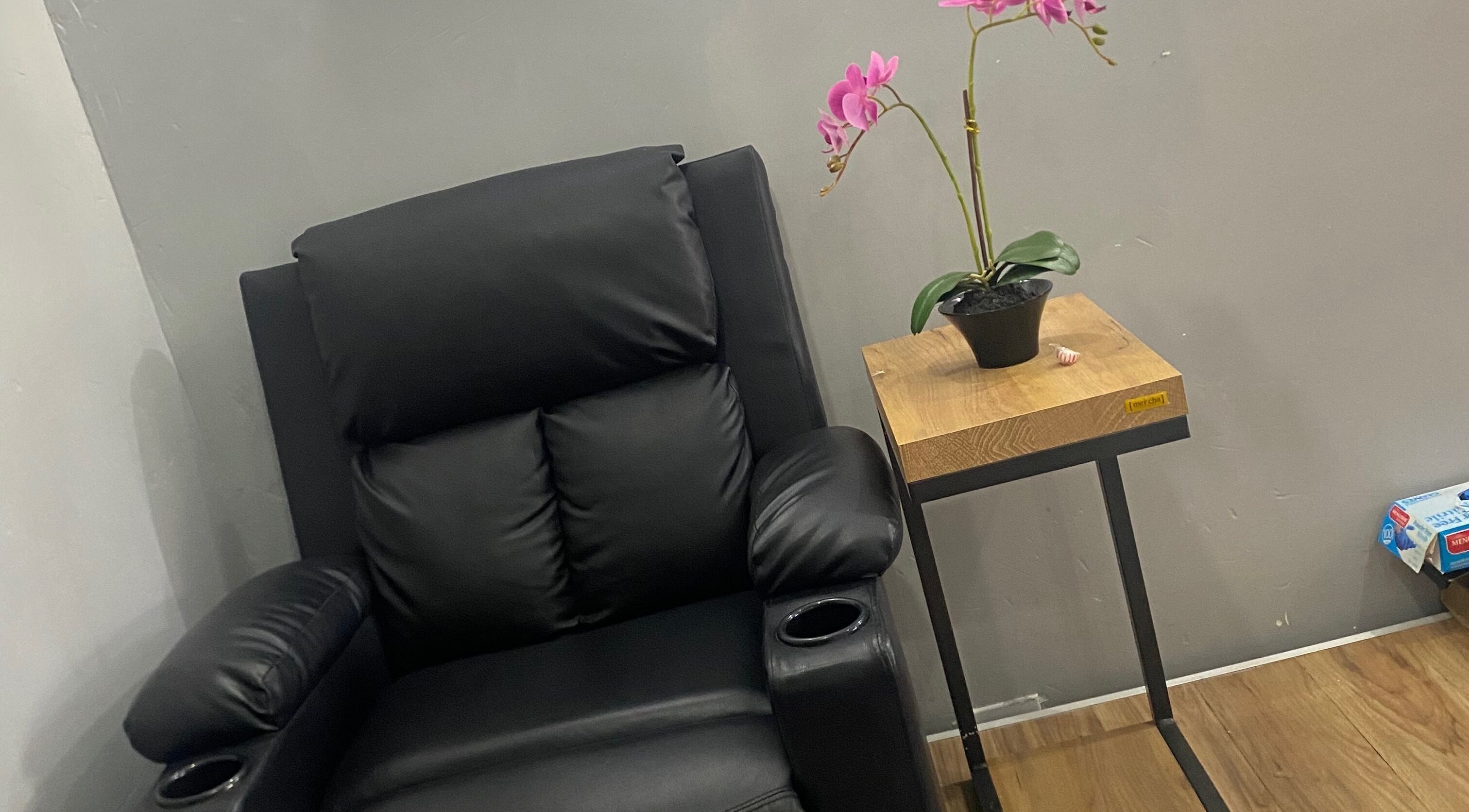 Plush black chair with orchid plant at Snique Allure, Montego Bay, St. James Parish, JM.