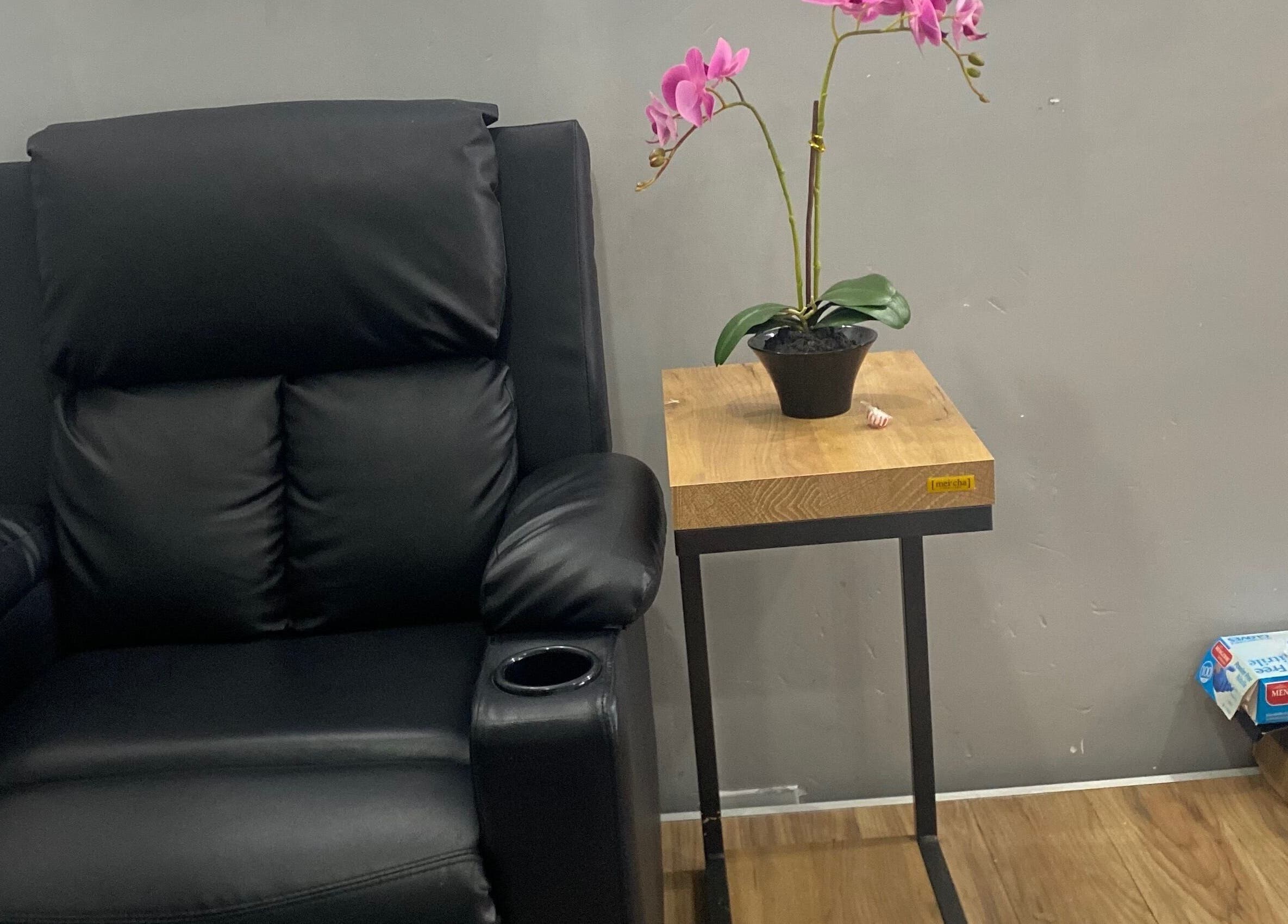 Cozy black recliner and orchid plant at Snique Allure, Montego Bay, St. James Parish, JM.
