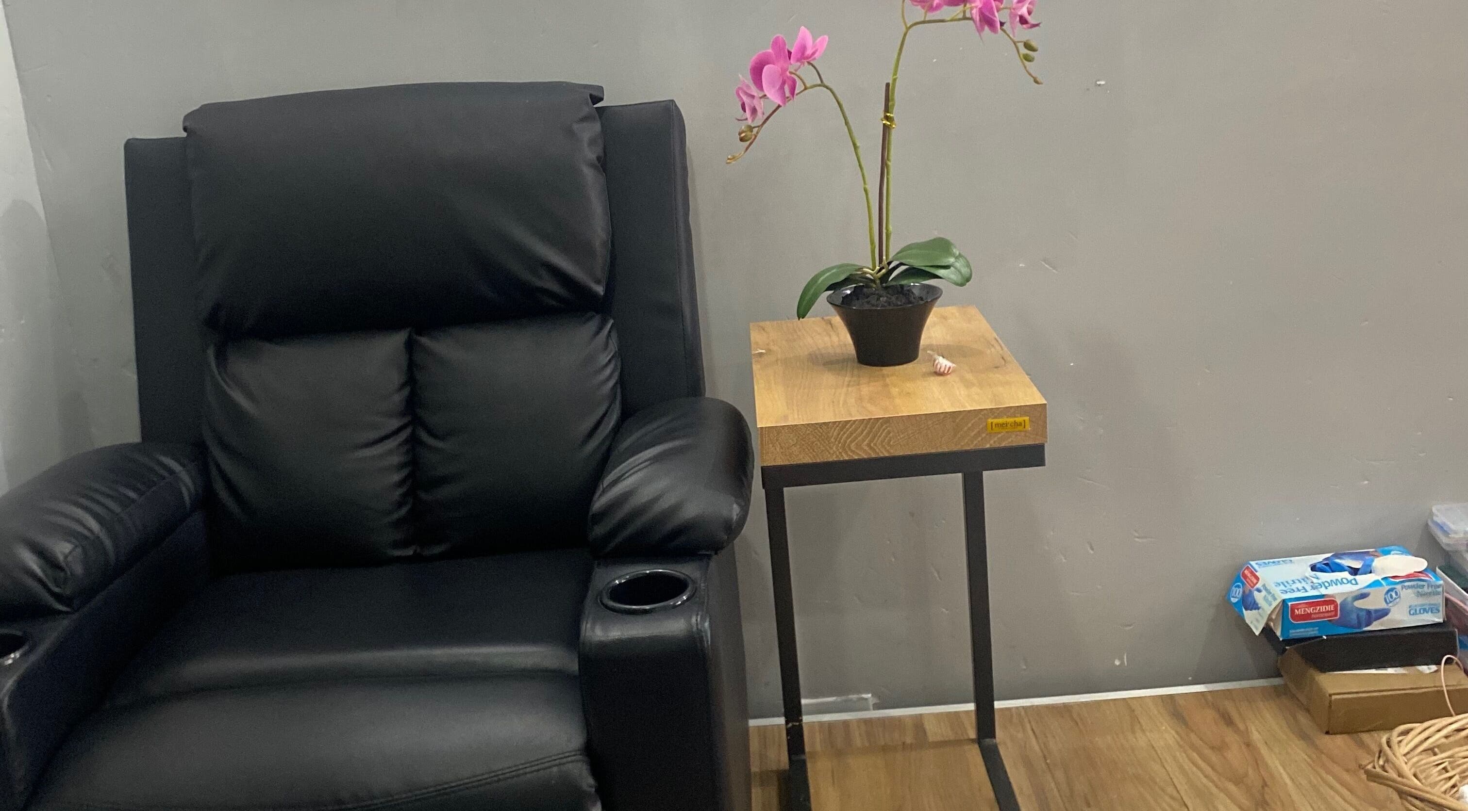 Cozy black recliner and orchid plant at Snique Allure, Montego Bay, St. James Parish, JM.