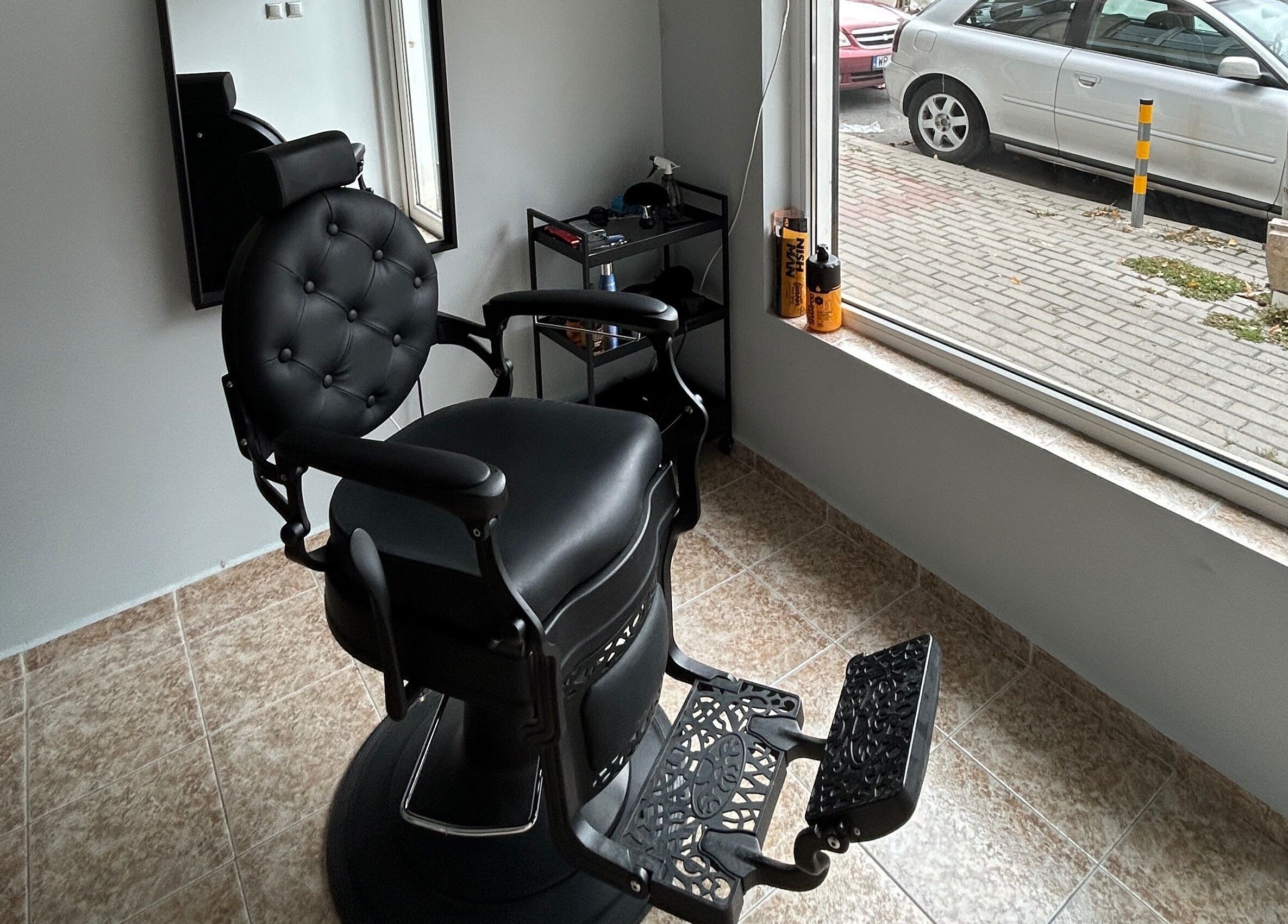 Modern black barber chair at MiriCutz in Varna, Varna, BG, near a bright window with street view.