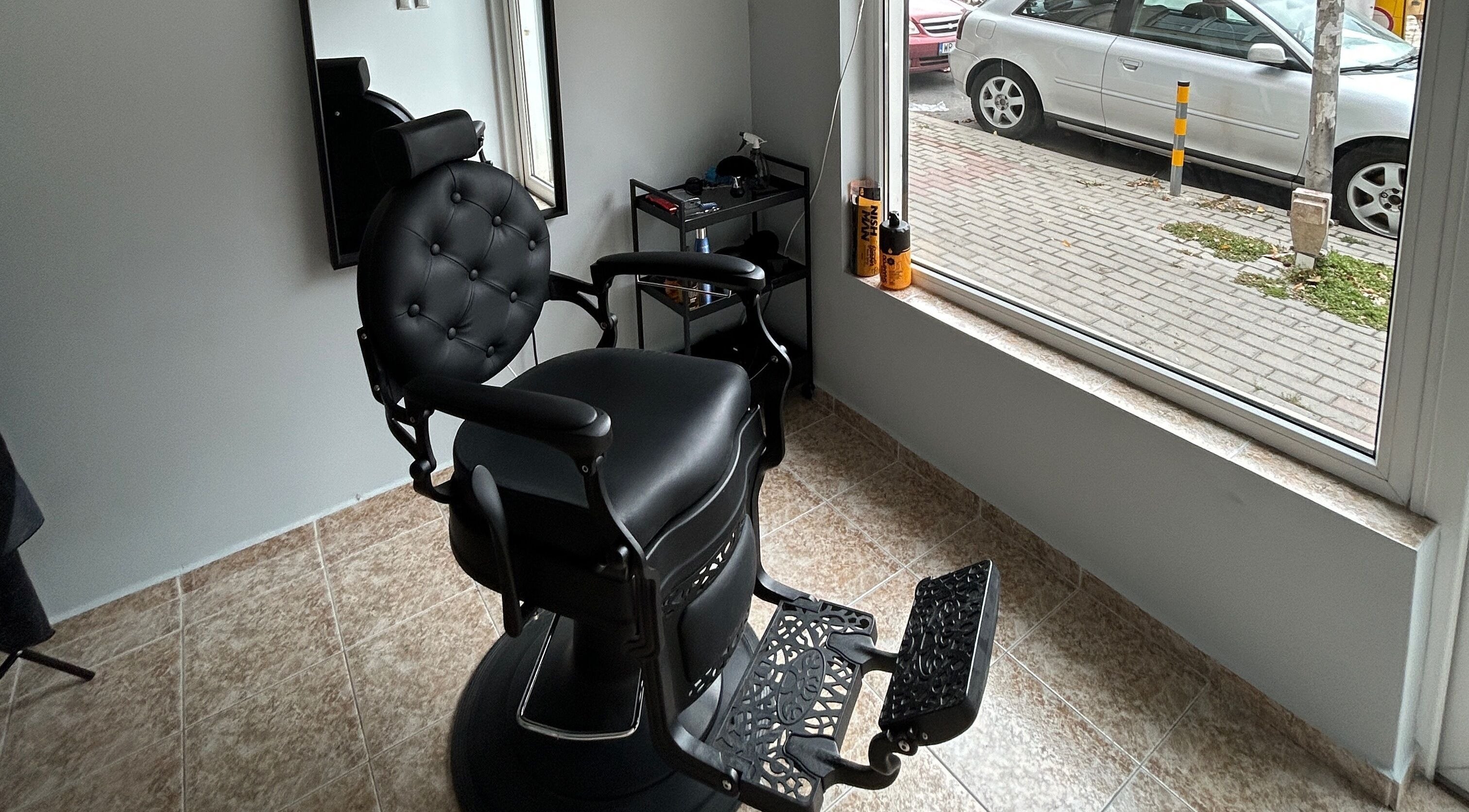 Modern black barber chair at MiriCutz in Varna, Varna, BG, near a bright window with street view.