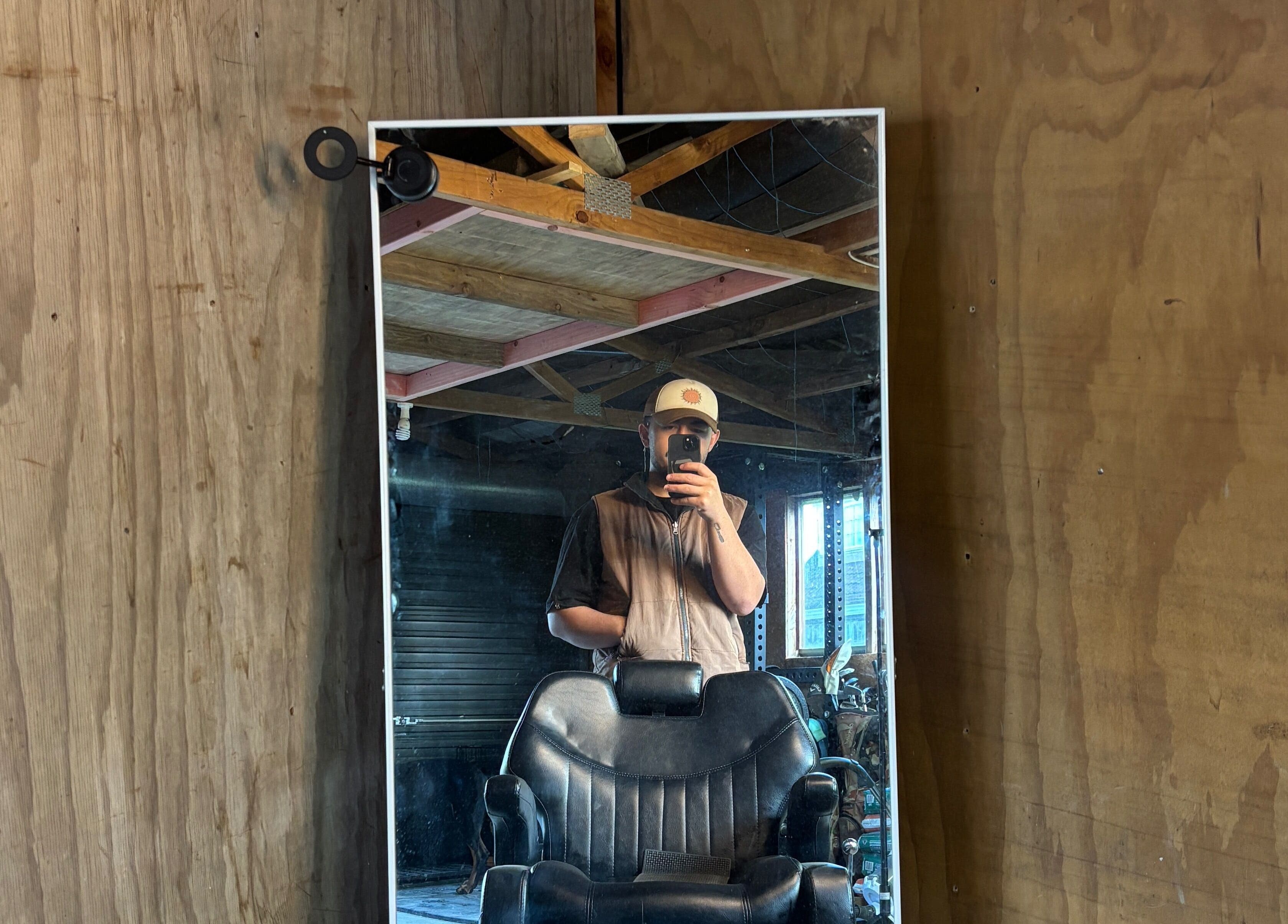 Rustic barber chair and mirror setup at Rubin Karere, Hamilton, Waikato Region, NZ reflecting a cozy ambiance.