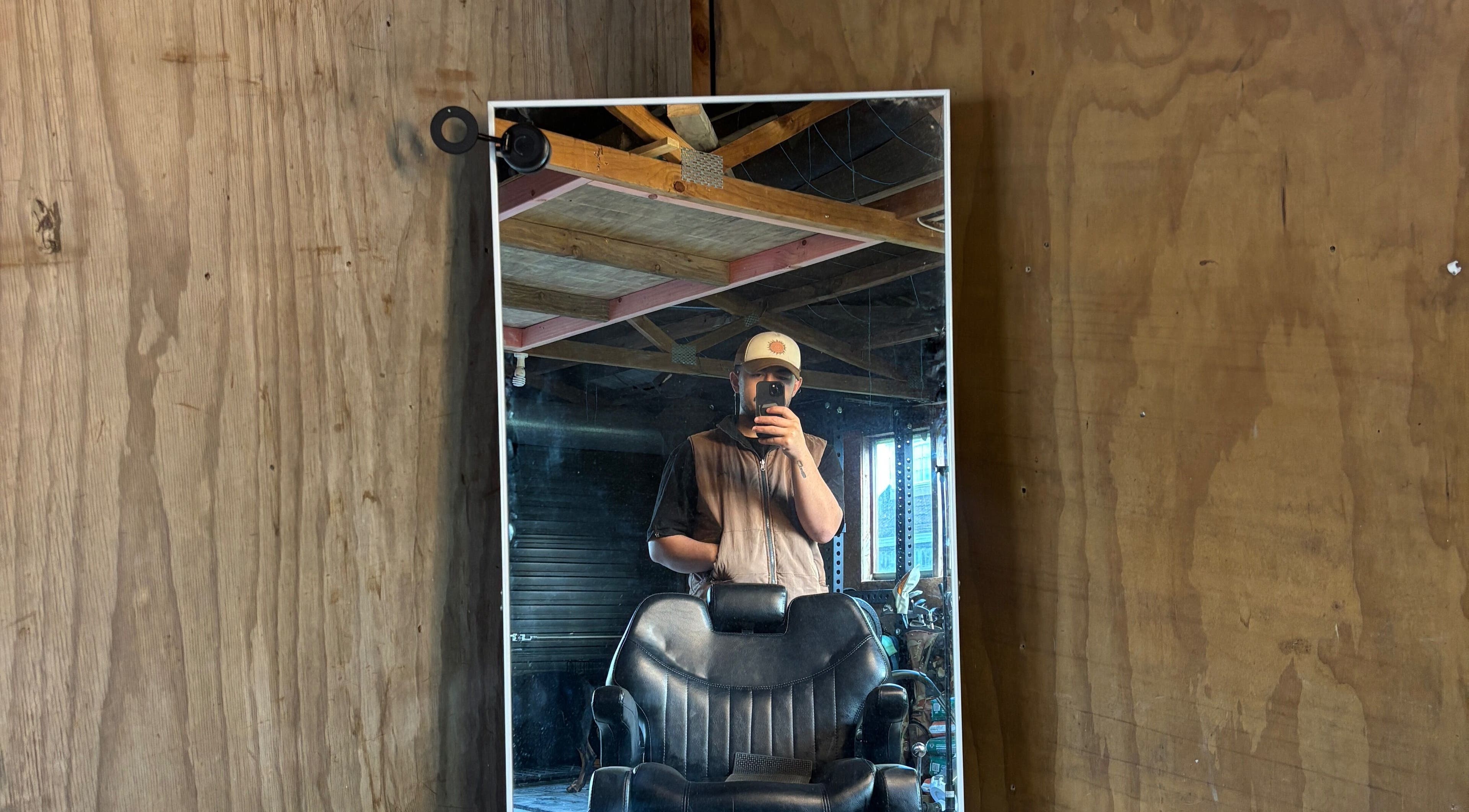 Rustic barber chair and mirror setup at Rubin Karere, Hamilton, Waikato Region, NZ reflecting a cozy ambiance.