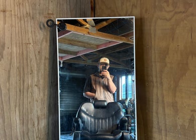 Cozy barber chair in Rubin Karere, Hamilton, Waikato Region, NZ, with rustic wood walls and vintage style.