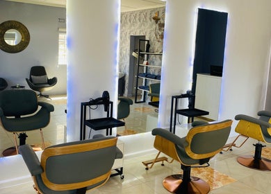 Modern salon interior at Beauty By Moi, Lusaka, Lusaka Province, ZM with stylish chairs and mirrors.