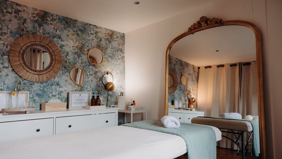 Salle de soins paisible à Wanessa Souissi, Bègles, Nouvelle-aquitaine, FR avec miroir et décor chaleureux.