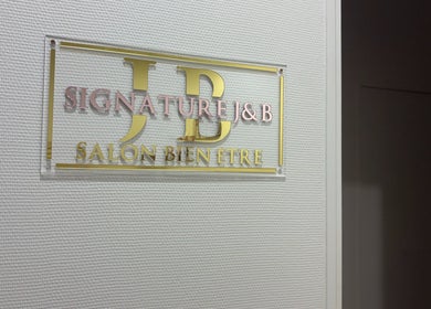 Panneau doré du salon Signature J&B à Tarbes, Occitanie, FR, affichant élégance et bien-être.