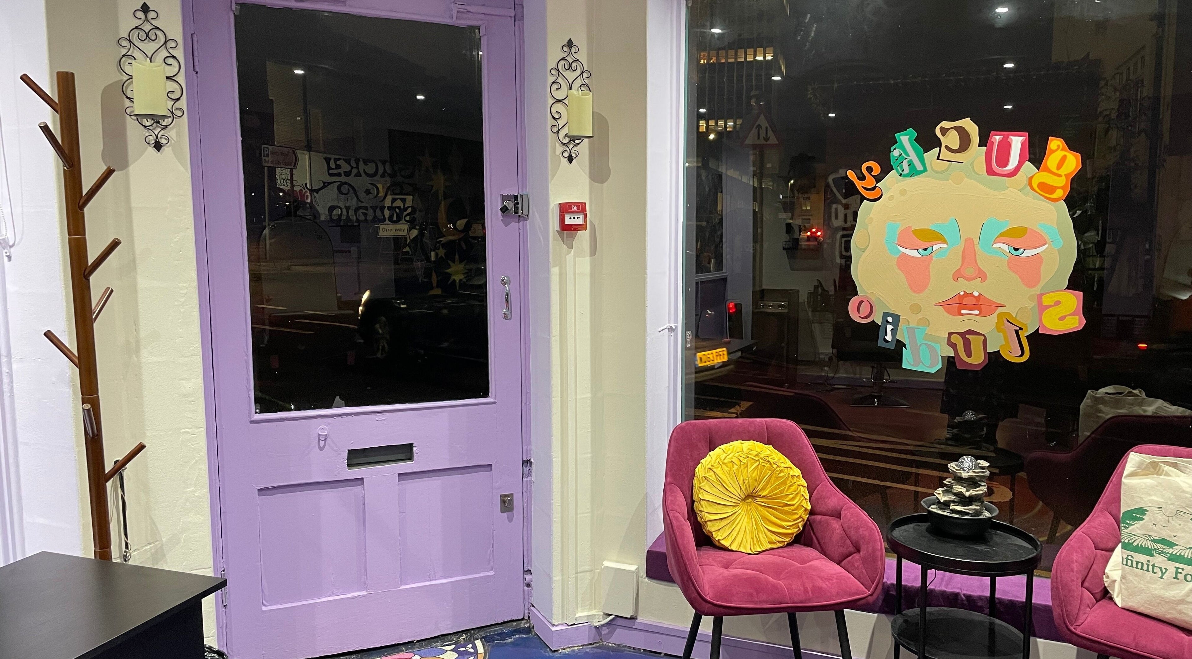 Vibrant waiting area at Poppy The Hair Fairy, Brighton And Hove, England, GB. Purple door and colorful artwork.