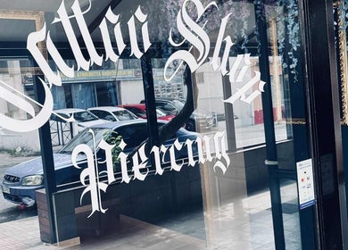 Πρόσοψη του INK FAME TATTOO SHOP στην Ίλιον, GR με έντονες επιγραφές και διακόσμηση.